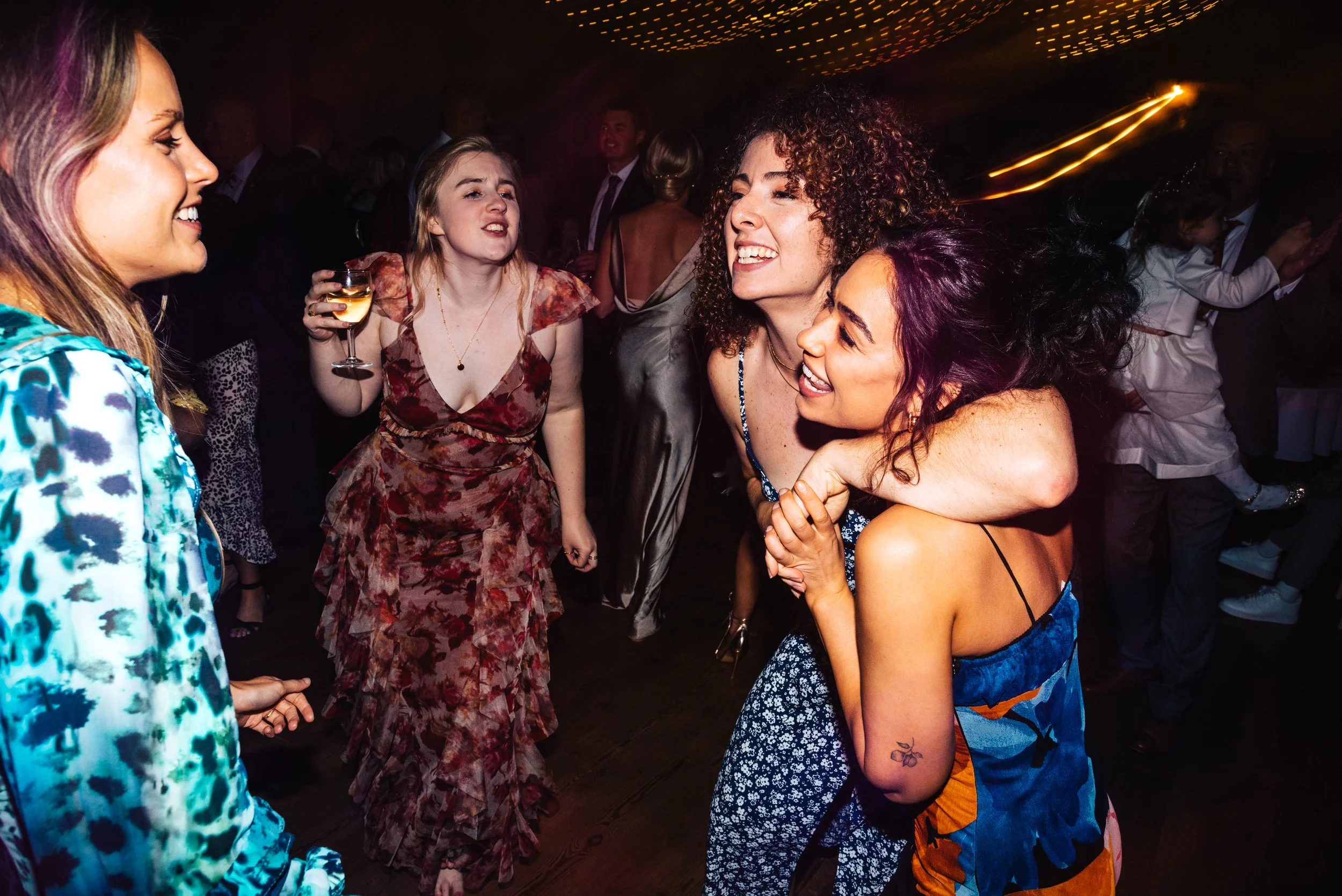 Group of women dancing and enjoying themselves at a lively party or celebration.