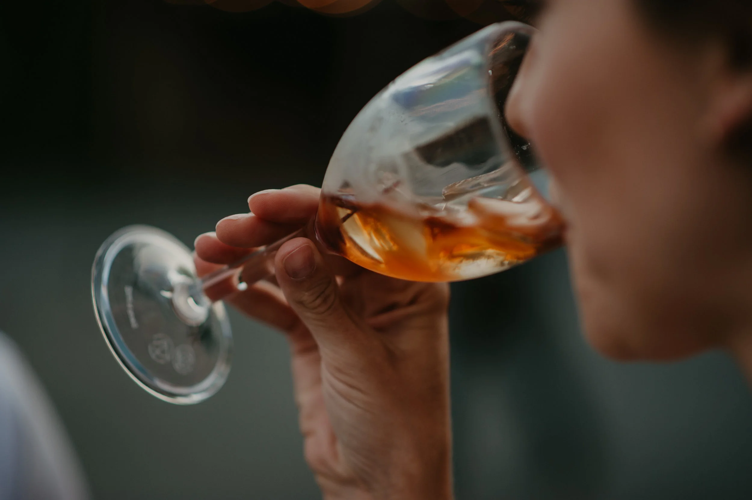 Person drinking rosé wine from a glass