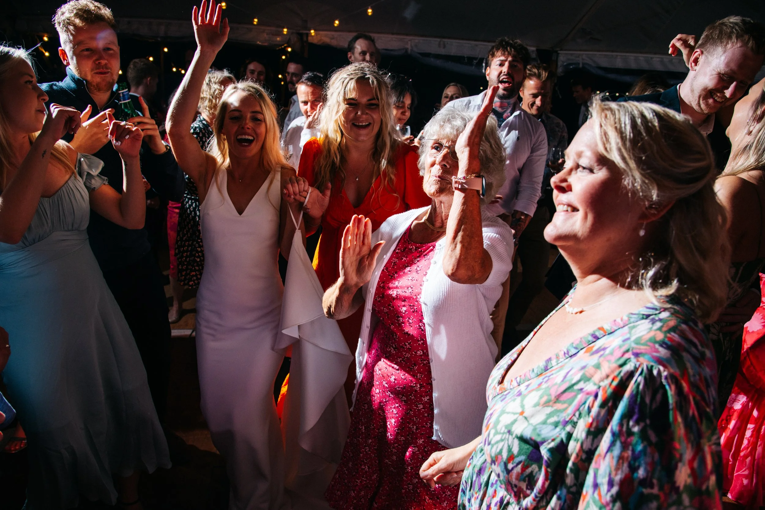 People dancing and celebrating at a party, including young and older women.