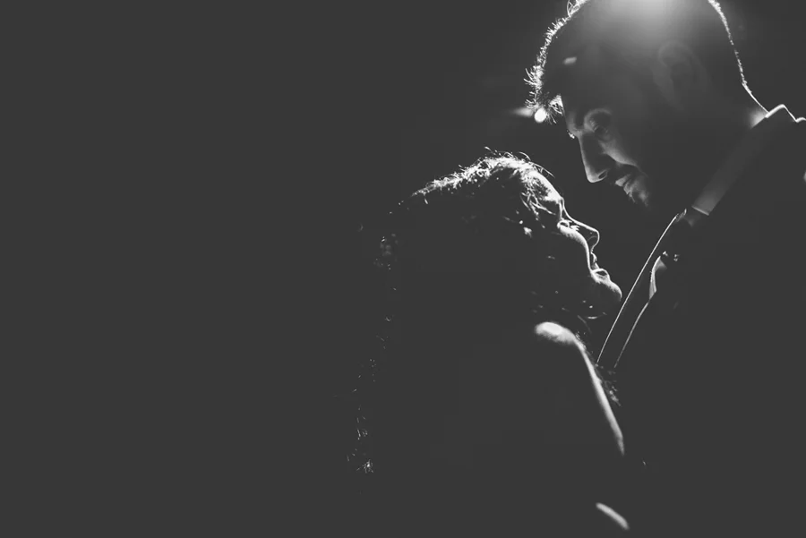 Black and white image of a couple gazing at each other in low light, captured by award-winning Cornwall wedding photographer, Mark Shaw. 