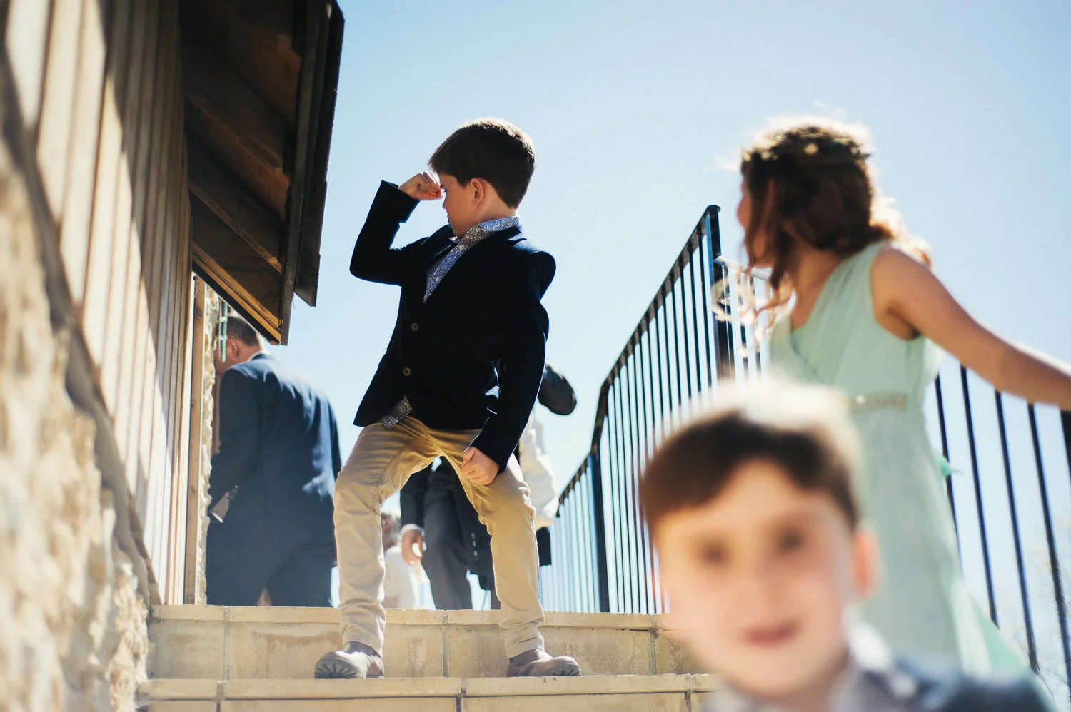 Children in formal clothing on outdoor stairs, sunny day