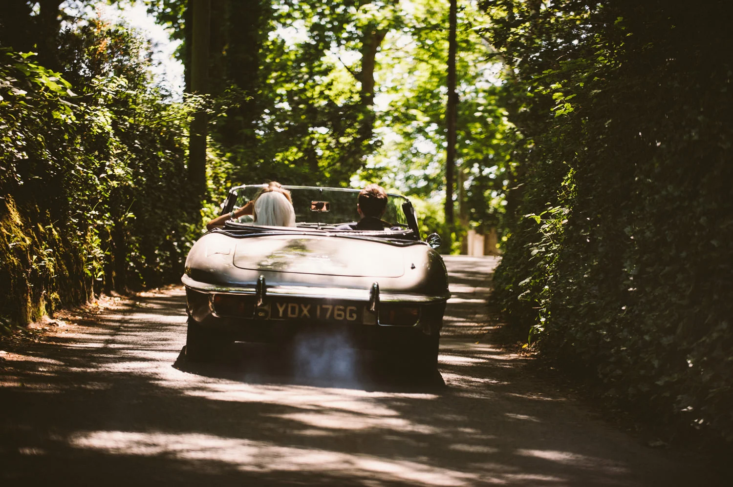 Bride and groom in vintage classic sports car in Cornwall, captured by Mark Shaw Photography.