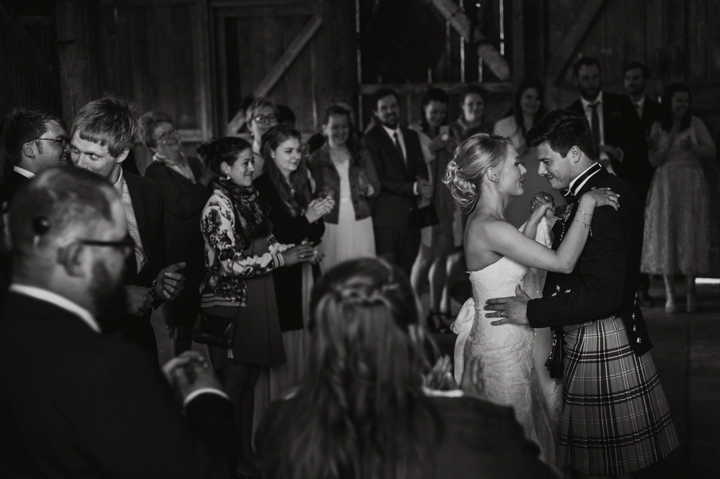 Bride and groom dancing in a barn with guests watching at Nancarrow Farm, captured by award-winning Cornwall wedding photographer, Mark Shaw. 