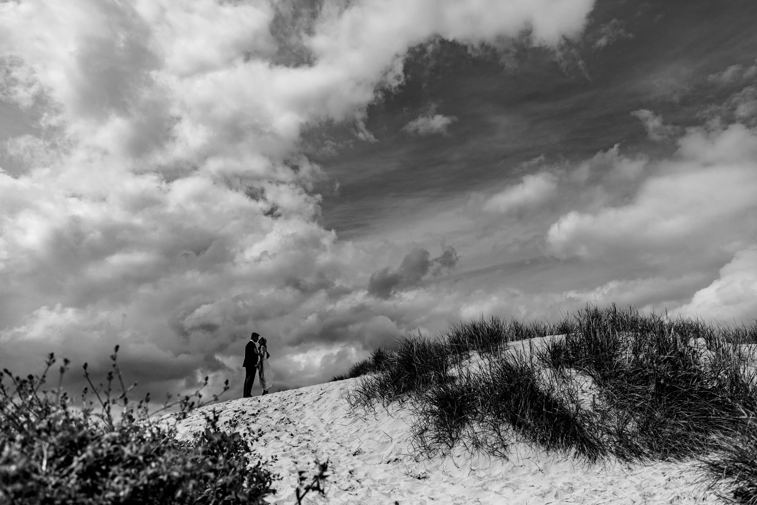 Bride and groom in sand dunes in black and white by Cornwall wedding photographer Mark Shaw Photography 