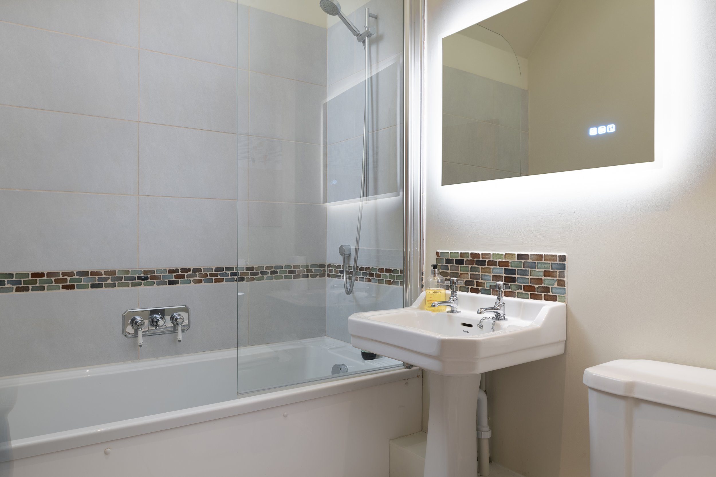 Bathroom with bathtub, shower, sink, and mirror