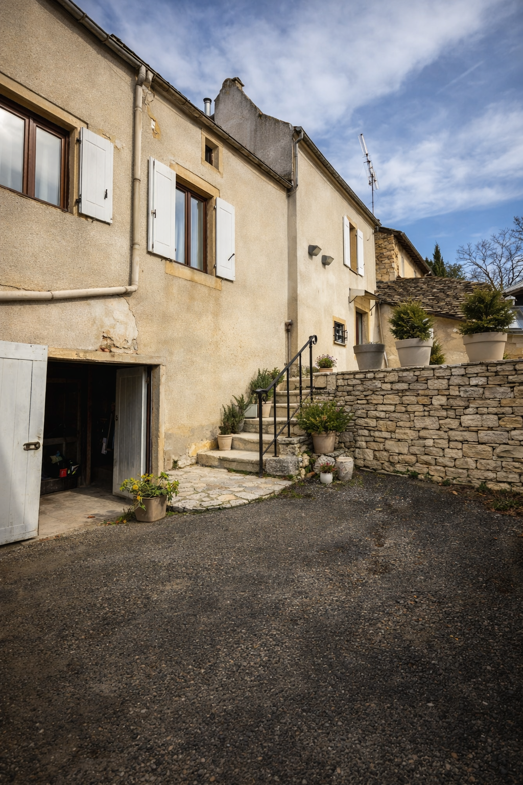 Charming stone house in courtyard setting.png