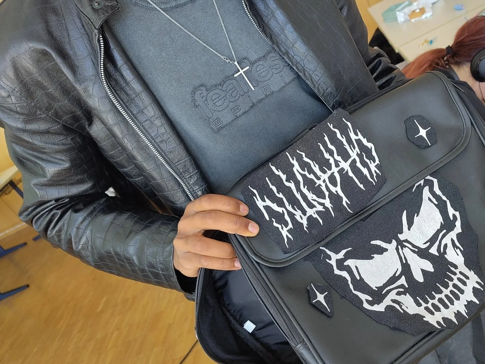 Ein Teilnehmer hält eine Laptoptasche in der Hand, deren Vorderseite mit neuen Motiven verziert wurde.