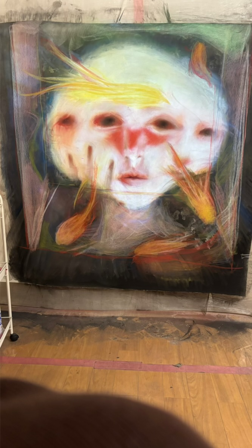Abstract artwork of a human face with distorted features, blending realistic facial elements with swirling, colorful brushstrokes, including orange fish-like shapes and yellow streaks.