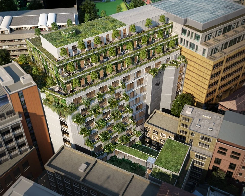 An aerial view of a modern high-rise building with a green rooftop garden and terraces decorated with trees and plants, surrounded by other urban buildings.