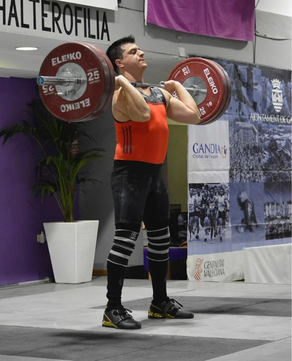 Imagen de entrenador levantando un barra de halterofilia.