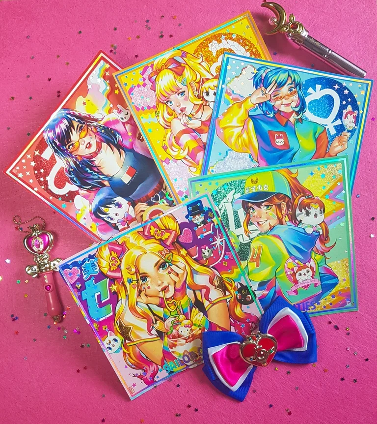 Colorful anime-style character illustrations on transparent stickers with glitter background, placed on a pink surface with star-shaped confetti, a pink heart-shaped wand, a rainbow-colored bow, and a silver star pen.