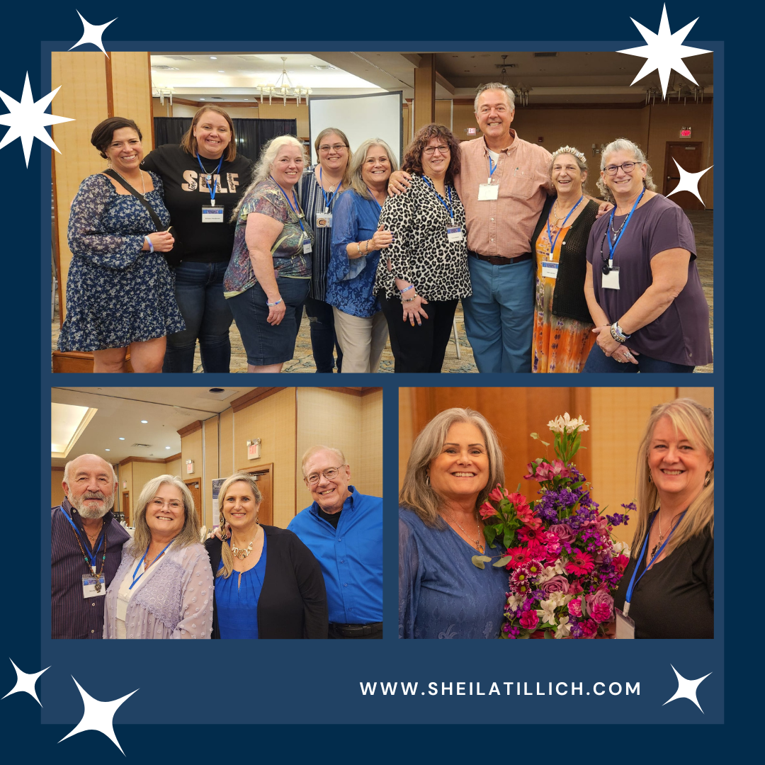 Group of people smiling at a conference, wearing name tags, with a woman holding a bouquet of flowers in front of a wooden background.