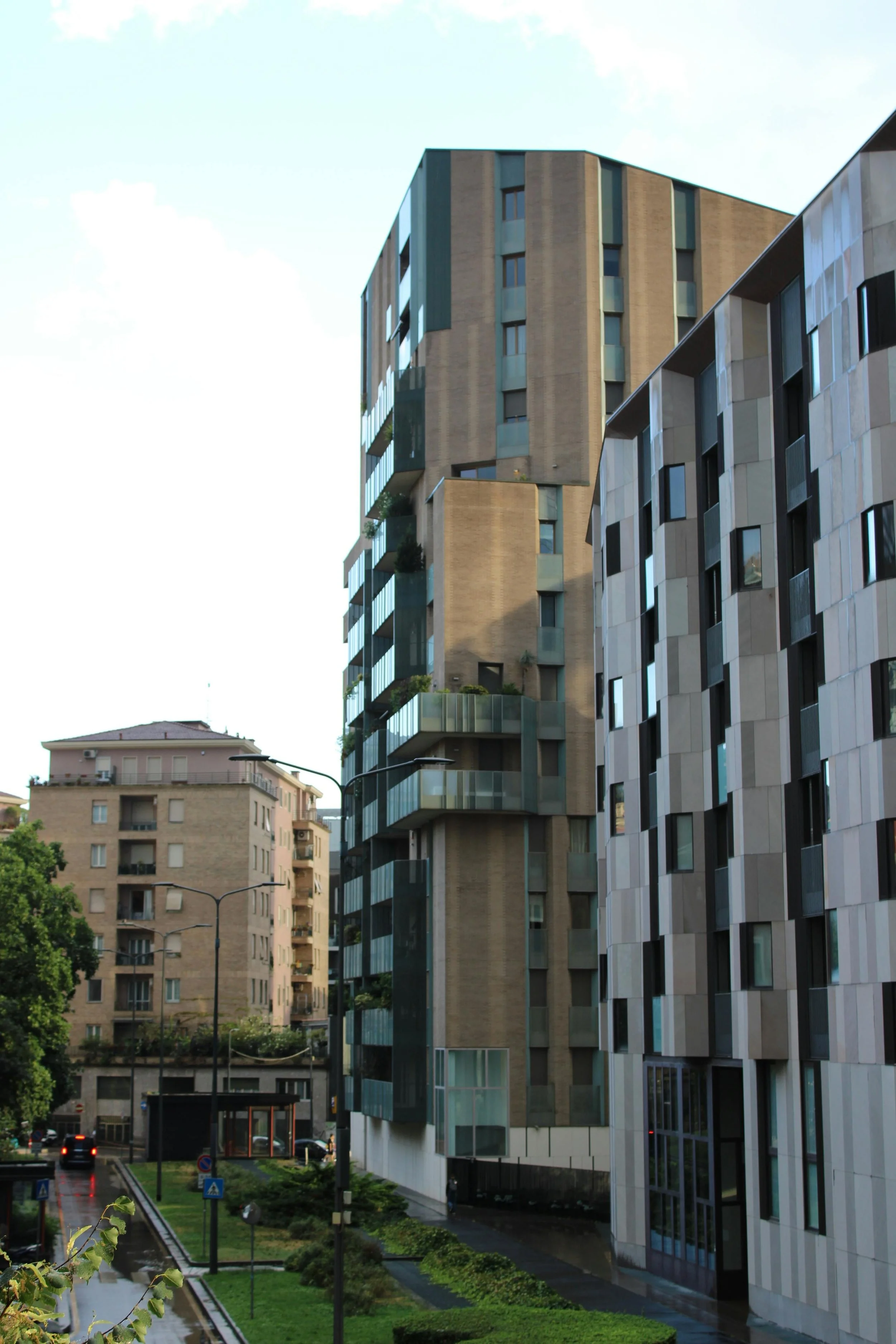 Edifici moderni con balconi in vetro e facciate in diversi materiali, in un quartiere residenziale della città.