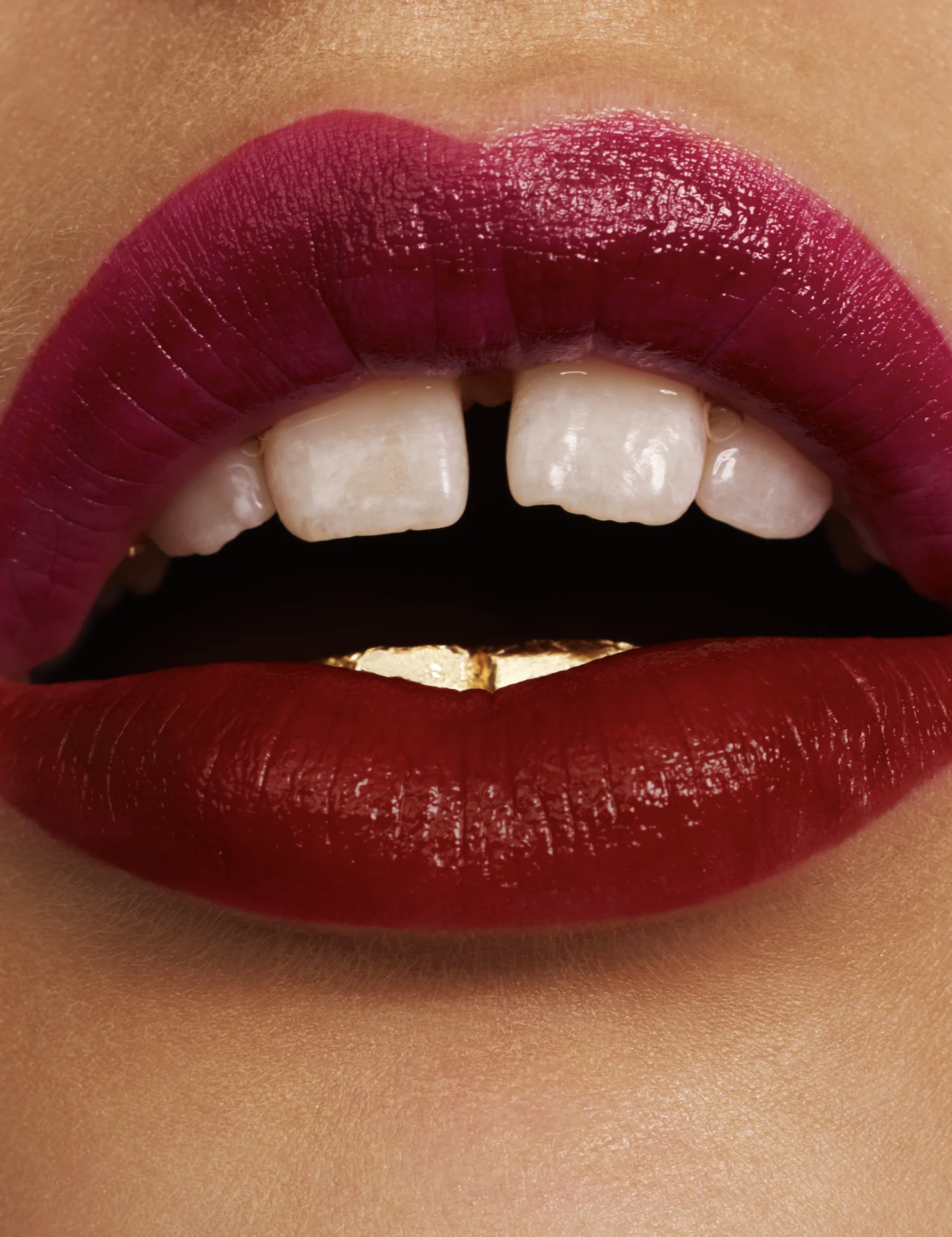 Close-up of lips with dark red lipstick, slightly parted to show teeth.