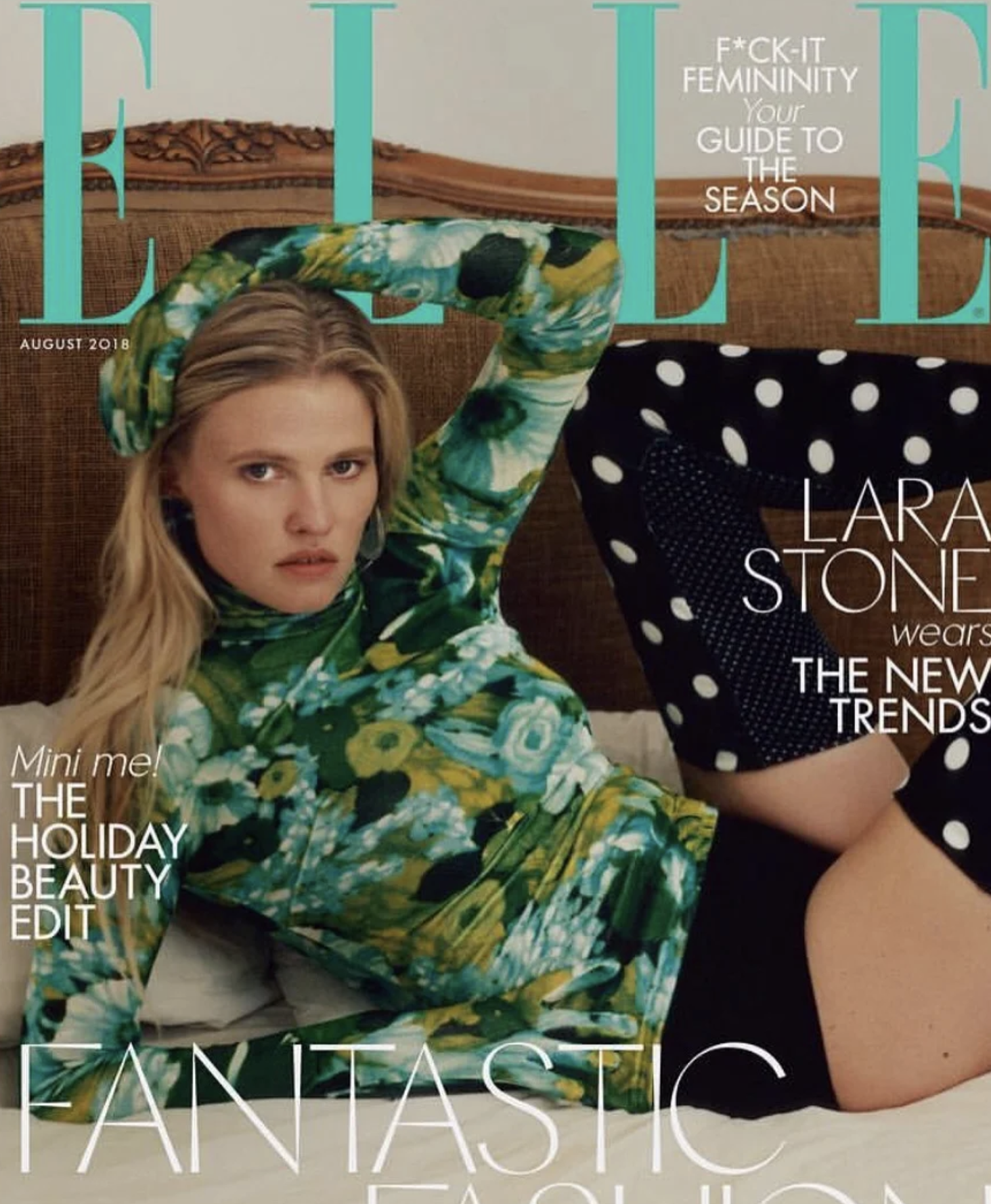 Cover of Elle magazine with a woman wearing a green floral dress and black polka dot skirt, sitting on a bed with an ornate wooden headboard, with headlines such as 'Mini me! The Holiday Beauty Edit' and 'Lara Stone wears the new trends'.