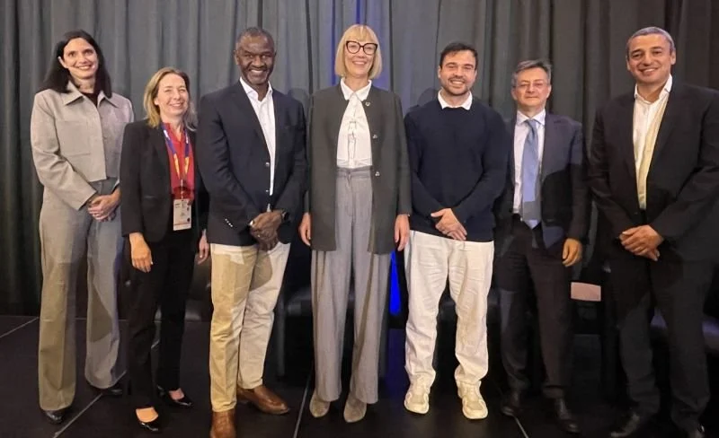 Gruppenfoto von Referent:innen auf einer Bühne bei einer Fachveranstaltung zu KI in der Onkologie