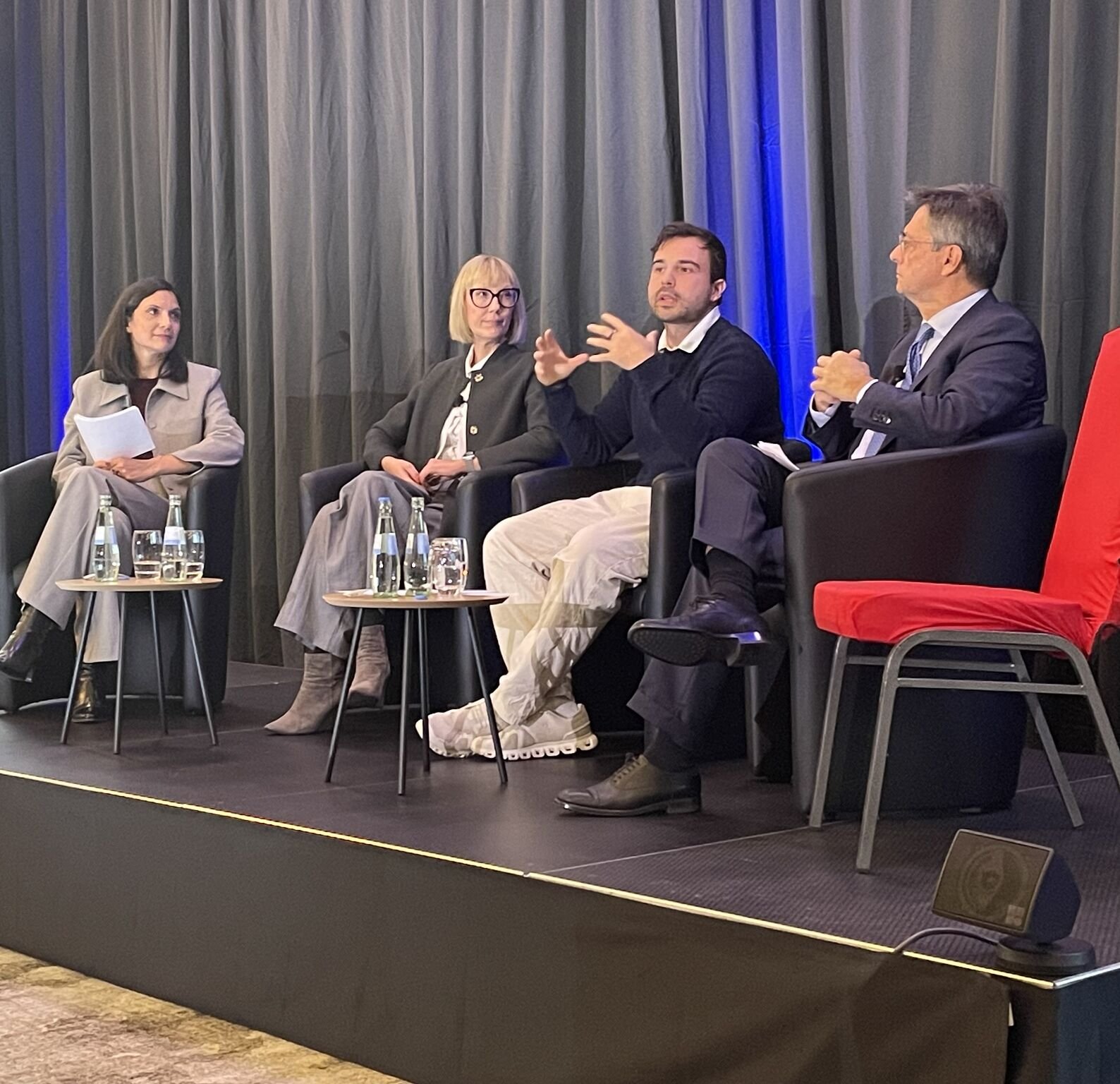 Paneldiskussion mit mehreren Teilnehmenden auf einer Bühne im Gespräch zu  Ki in der Onkologie.