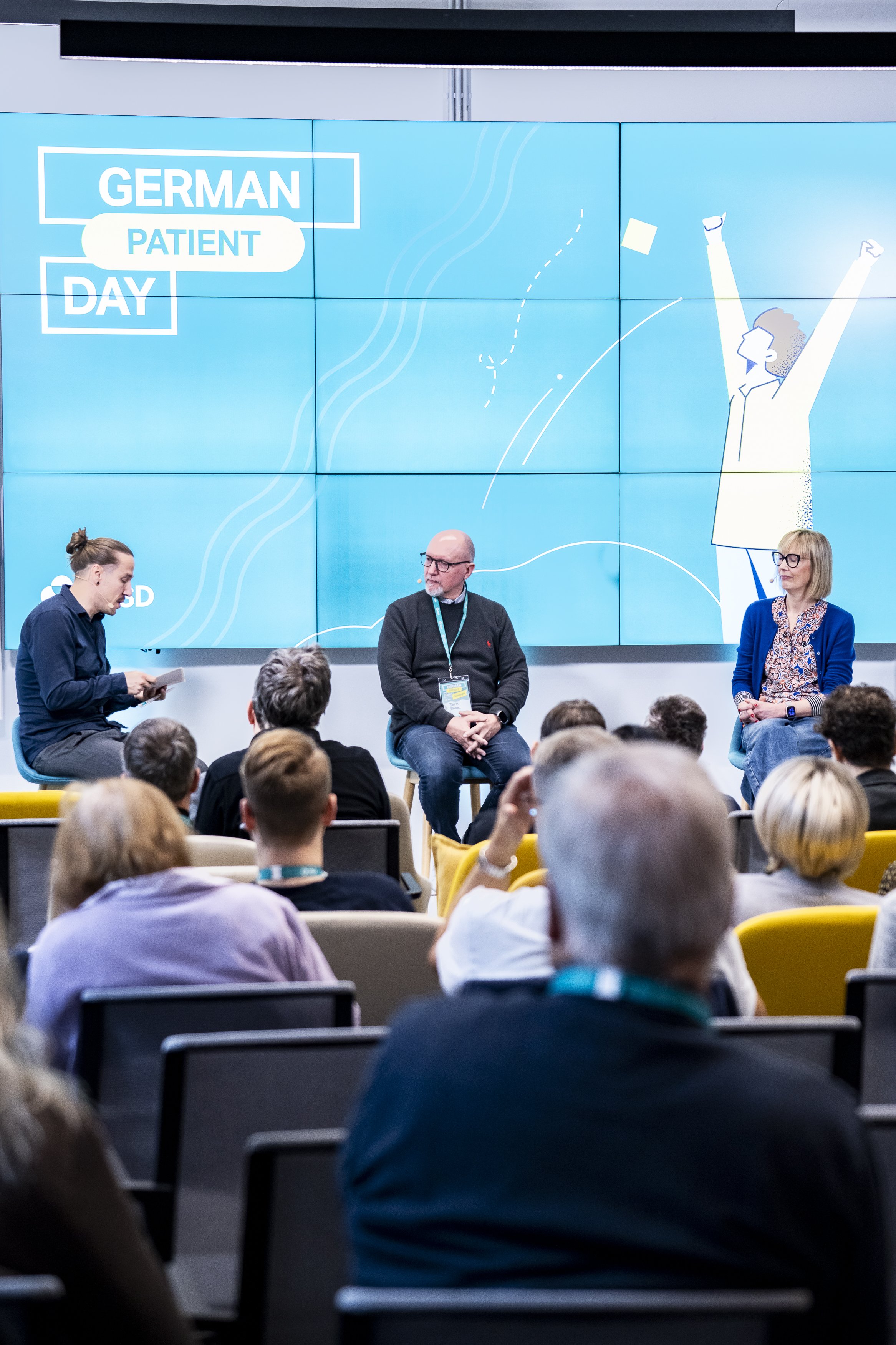 Paneldiskussion auf einer Konferenz mit mehreren Teilnehmenden im Austausch zu Gesundheit, KI und Gesellschaft.