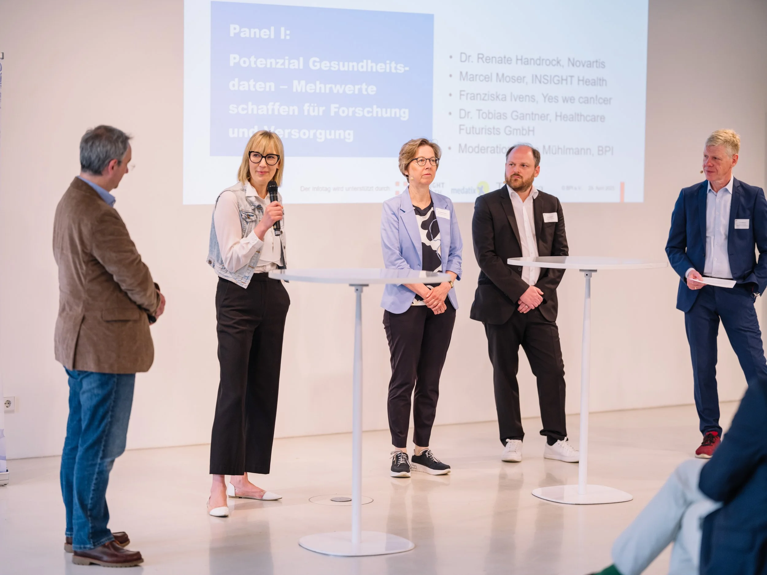 Paneldiskussion auf einer Konferenz mit mehreren Speaker:innen auf der Bühne zu Themen rund um Gesundheit, Daten, KI und gesellschaftliche Fragen.