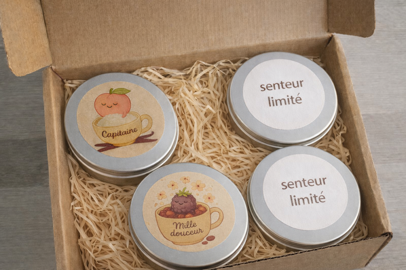 Boîte en carton contenant quatre petits pots avec des étiquettes illustrées, deux d'entre eux étiquetés 'senteur limité' et deux avec des illustrations florales et fruits.