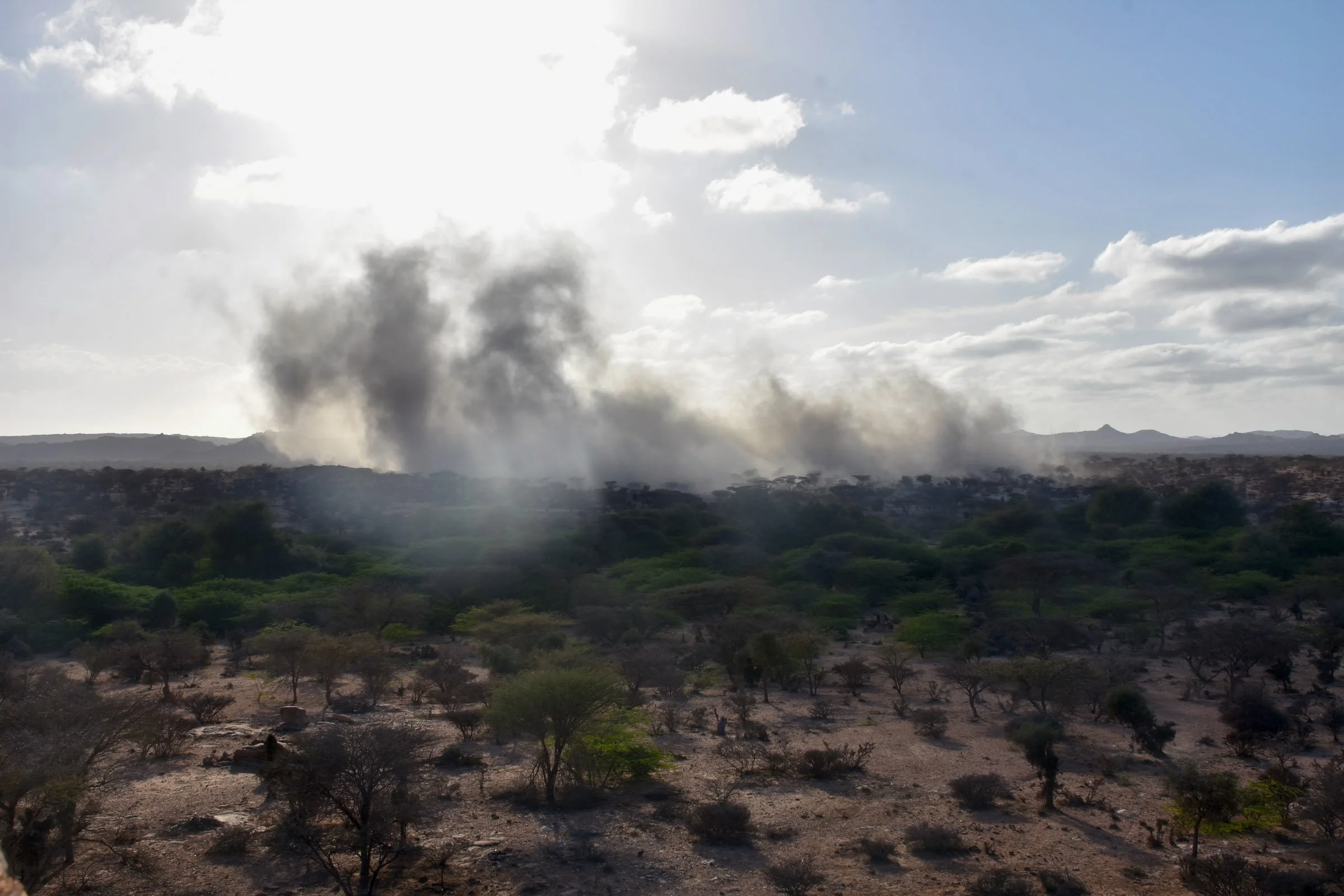 Smoke settles over a landscape of trees and peaks