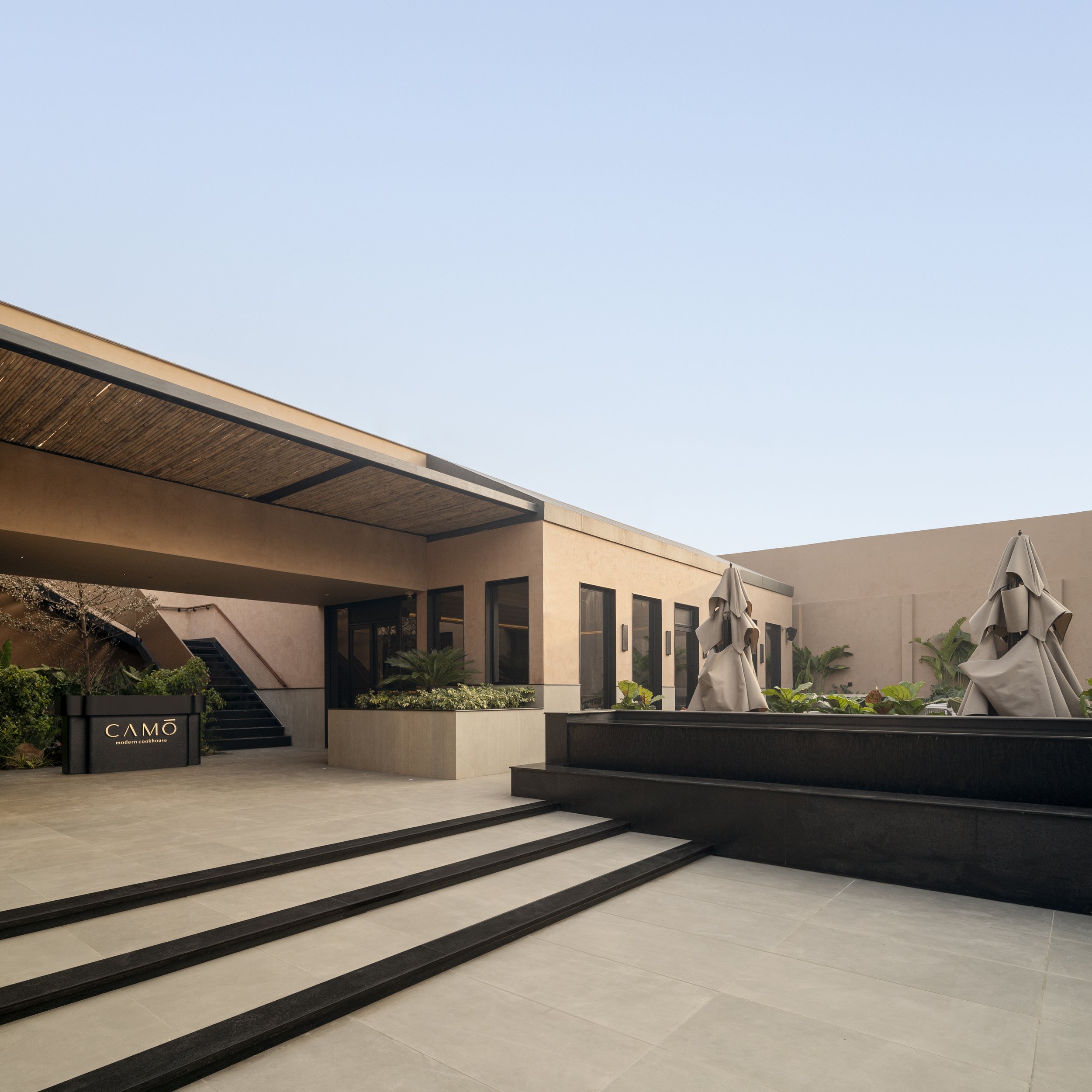 16_ENTRANCE TO THE COMPOUND LOOKING AT THE OUTDOOR SEATING AREA AND THE WATER BODY.jpg