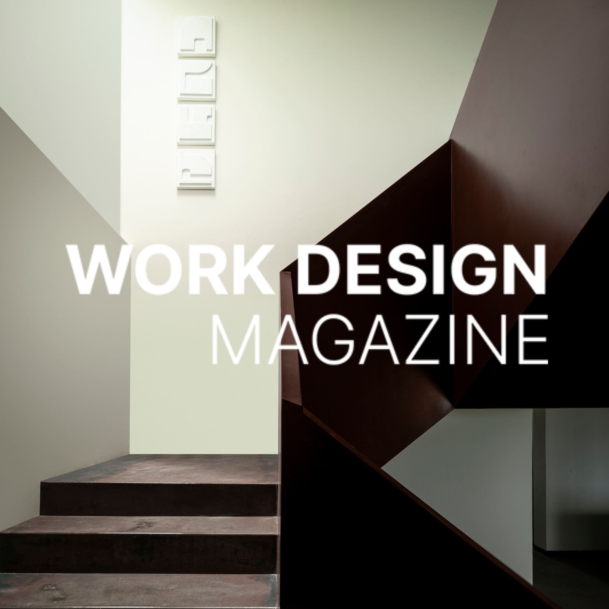 Interior of a modern building with a staircase and a wall sign that says "DESIGN".