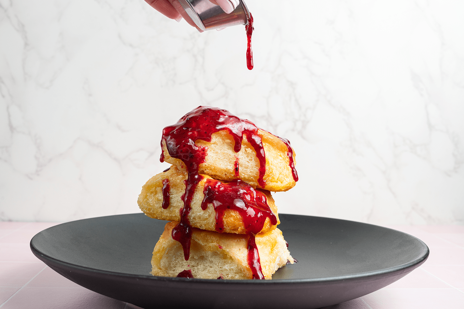 Stack of biscuits topped with berry sauce.