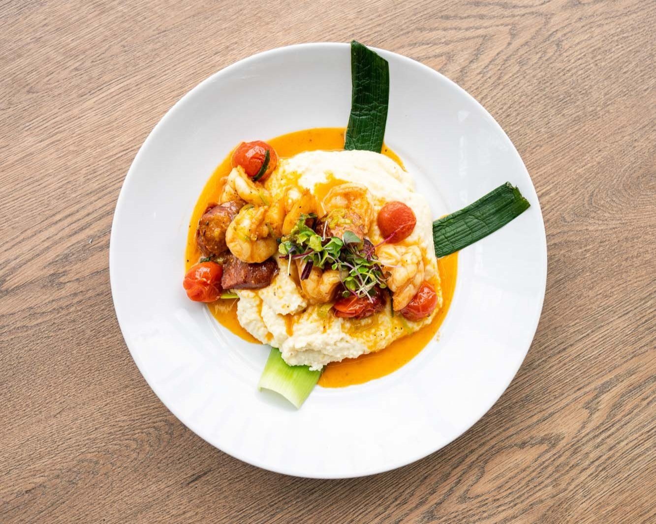 A white plate with shrimp and tomato sauce, a delicious seafood dish.