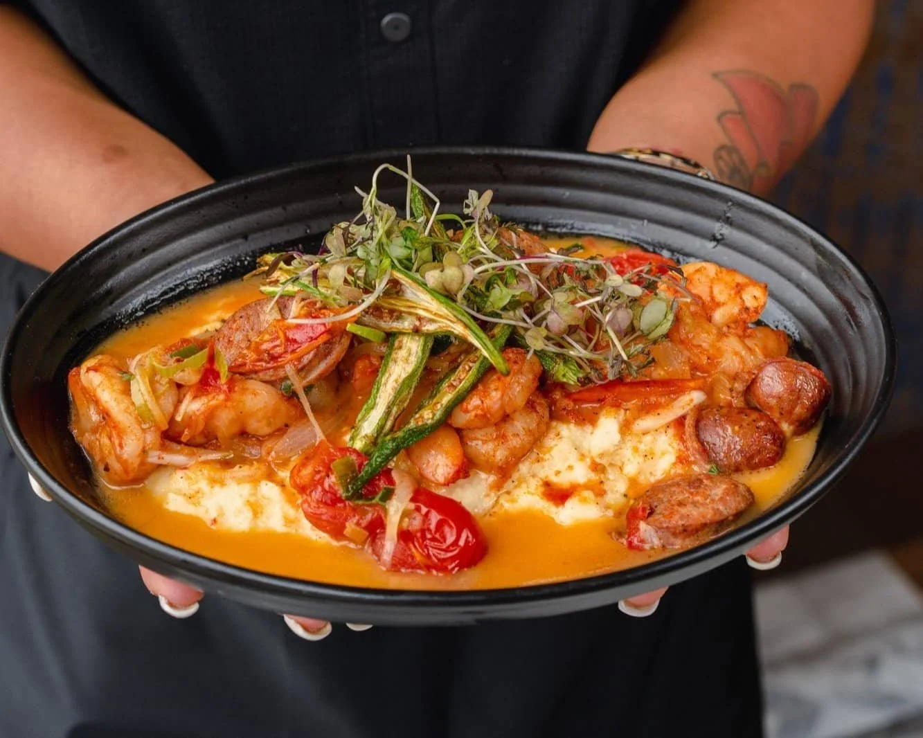 A person holding a bowl of delicious shrimp and vegetable dish, ready to be savored.