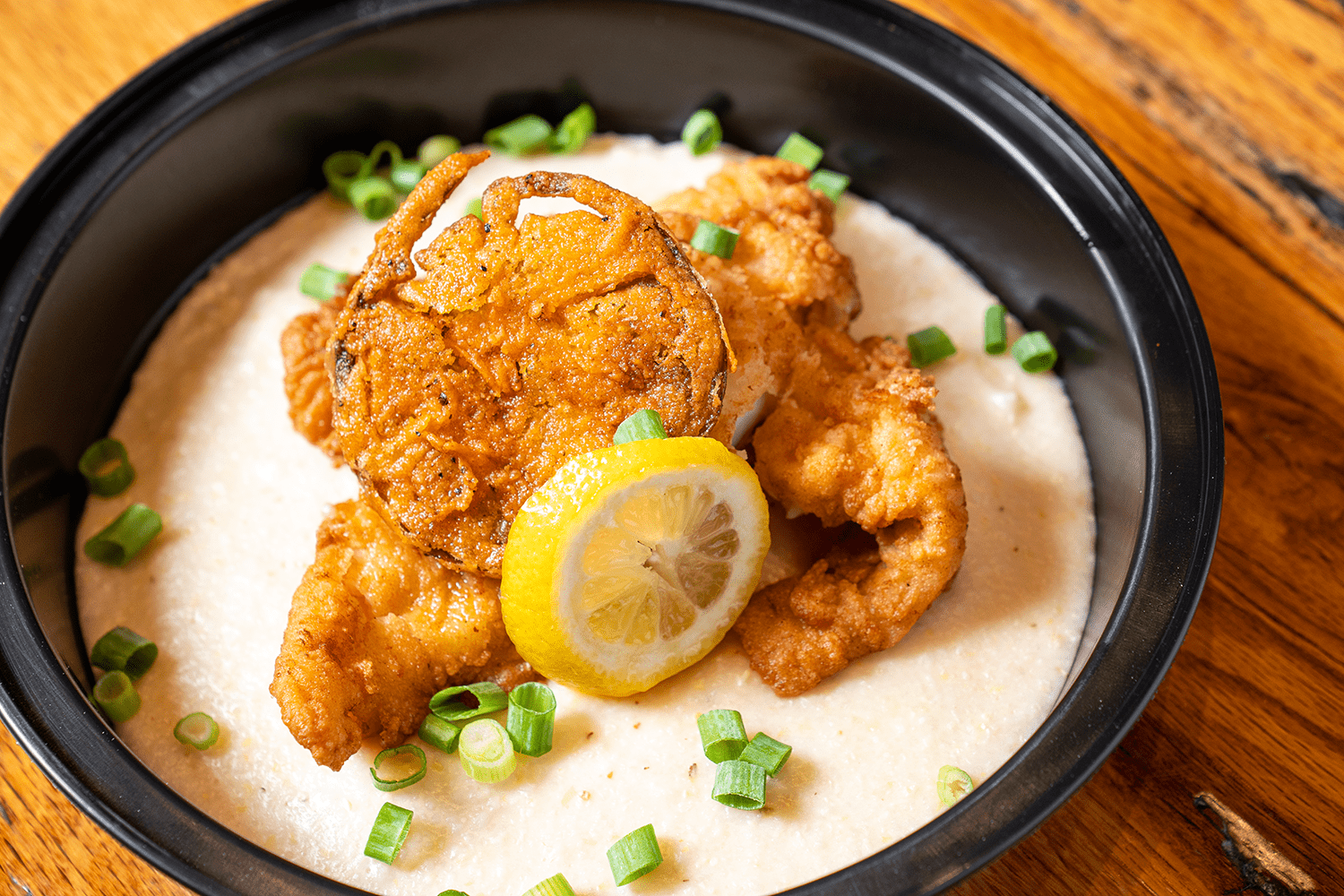 Fried catfish over creamy grits with lemon and scallions.