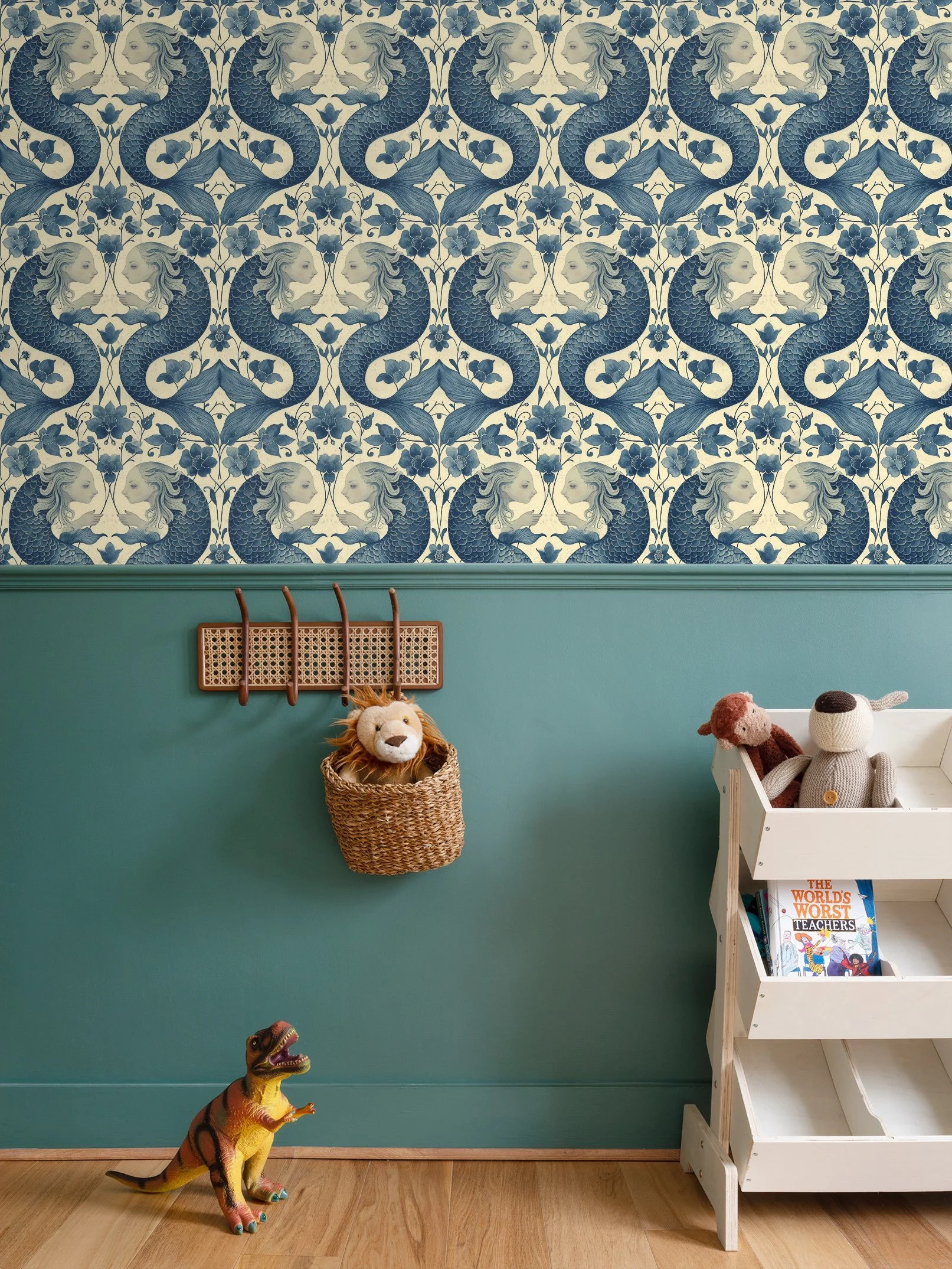 A children's room with a blue and white mermaid wallpaper, a green lower wall, and a wooden floor. There is a white shelf with stuffed animals and a children's book. A dinosaur toy stands on the floor, and a wall hook holds a basket with a lion stuffed animal hanging from it.