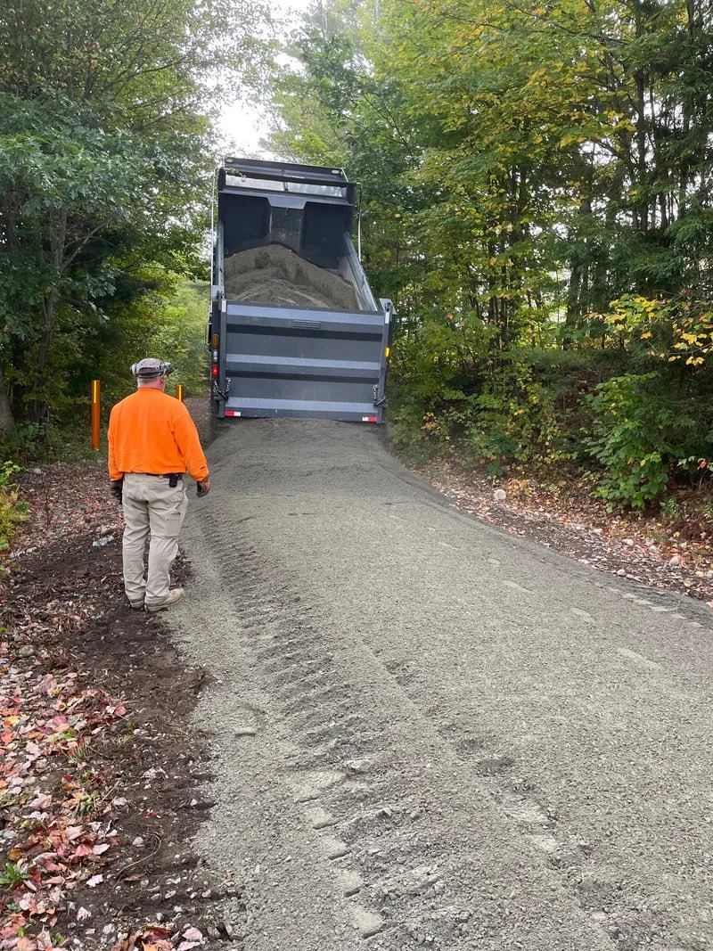 Watching the delivery of ledgepack to the Ammonoosuc Rail Trail in Littleton is Don of Romick Developers (Berlin, NH). Don is an expert sculptor with a bulldozer, he will grade this new surface to a smooth, solid, weather and use resistant surface th