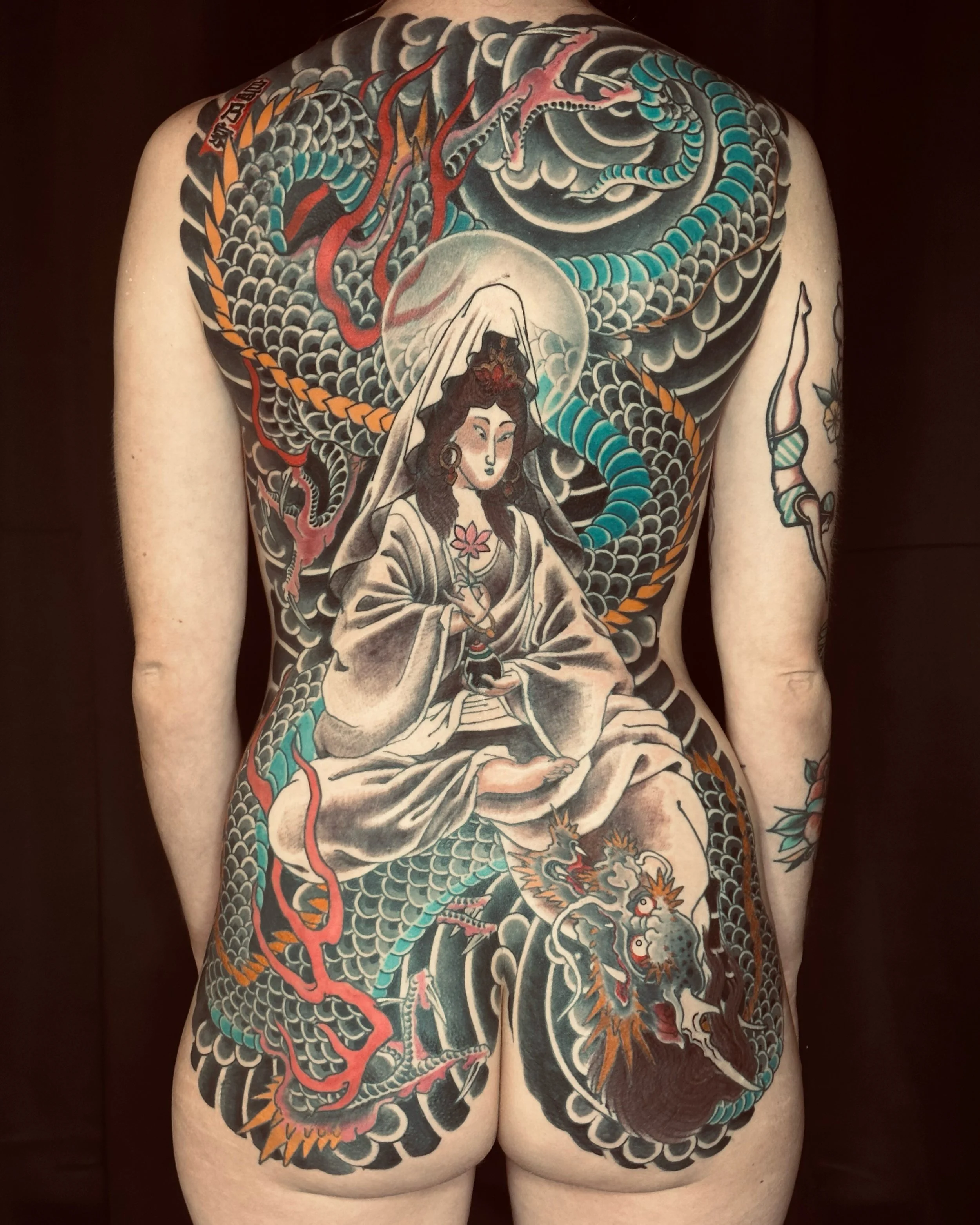 Tatouage traditionnel japonais couvrant le dos, représentant un dragon, une femme portant un kimono, des nuages, et des éléments mythologiques.