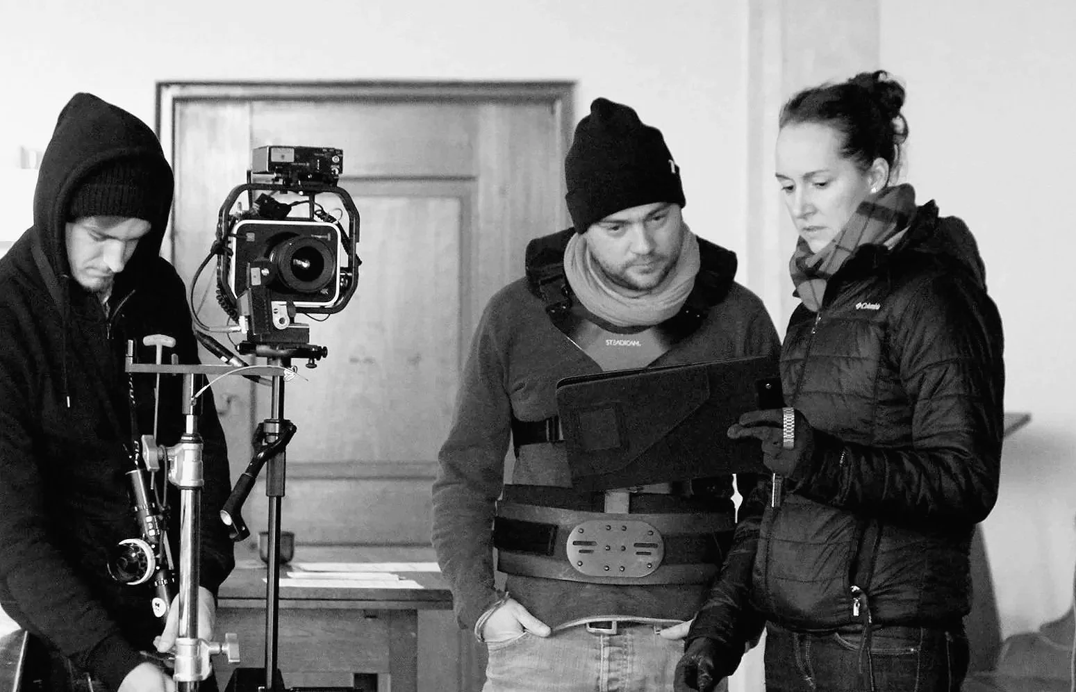 Gruppen von Filmemachern beim Filmdreh, Kamera und Regiearbeiten, in einem Innenraum.