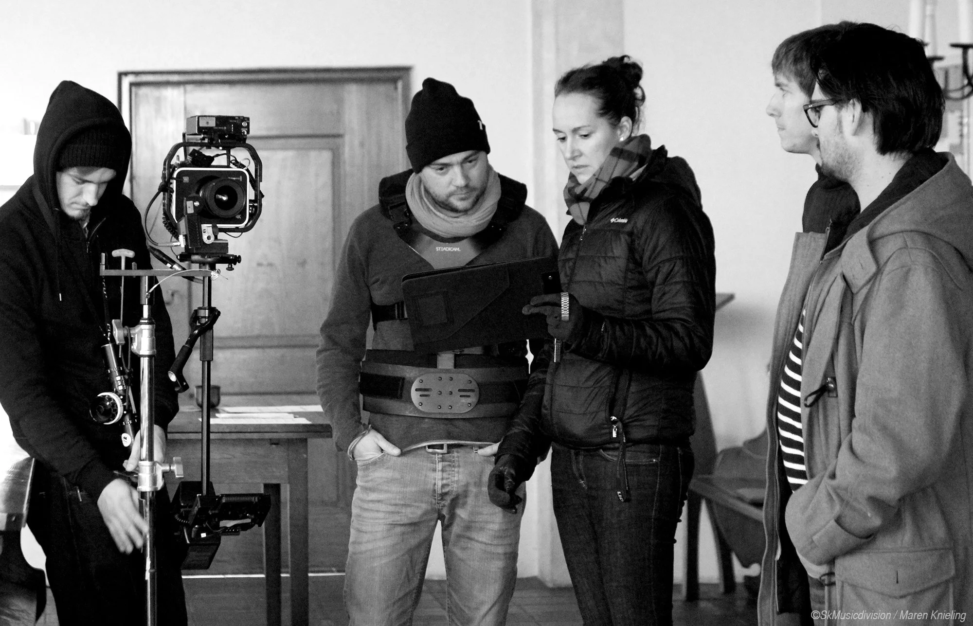 Gruppen von Filmemachern beim Filmdreh, Kamera und Regiearbeiten, in einem Innenraum.