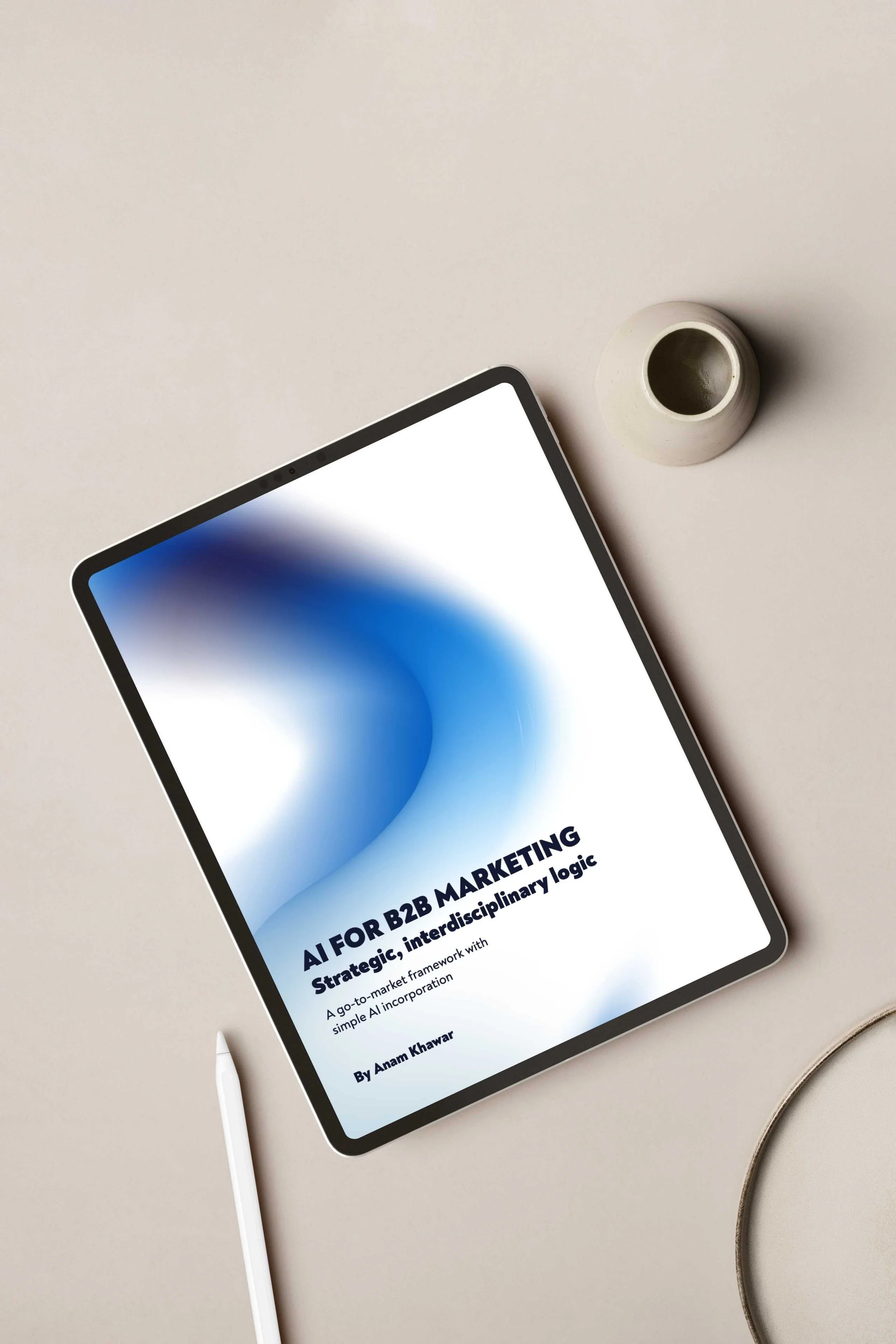 Book titled 'AI For B2B Marketing: Strategic, interdisciplinary logic' by Arun Kharvar on a tablet, placed on a white surface with a digital pen, small white vase, and part of a bracelet visible.