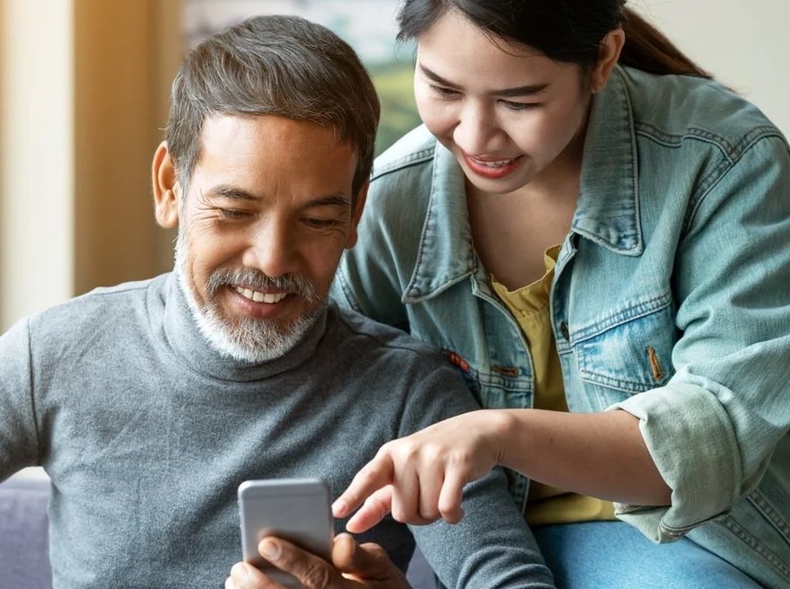 Mature Asian man and woman looking at phone