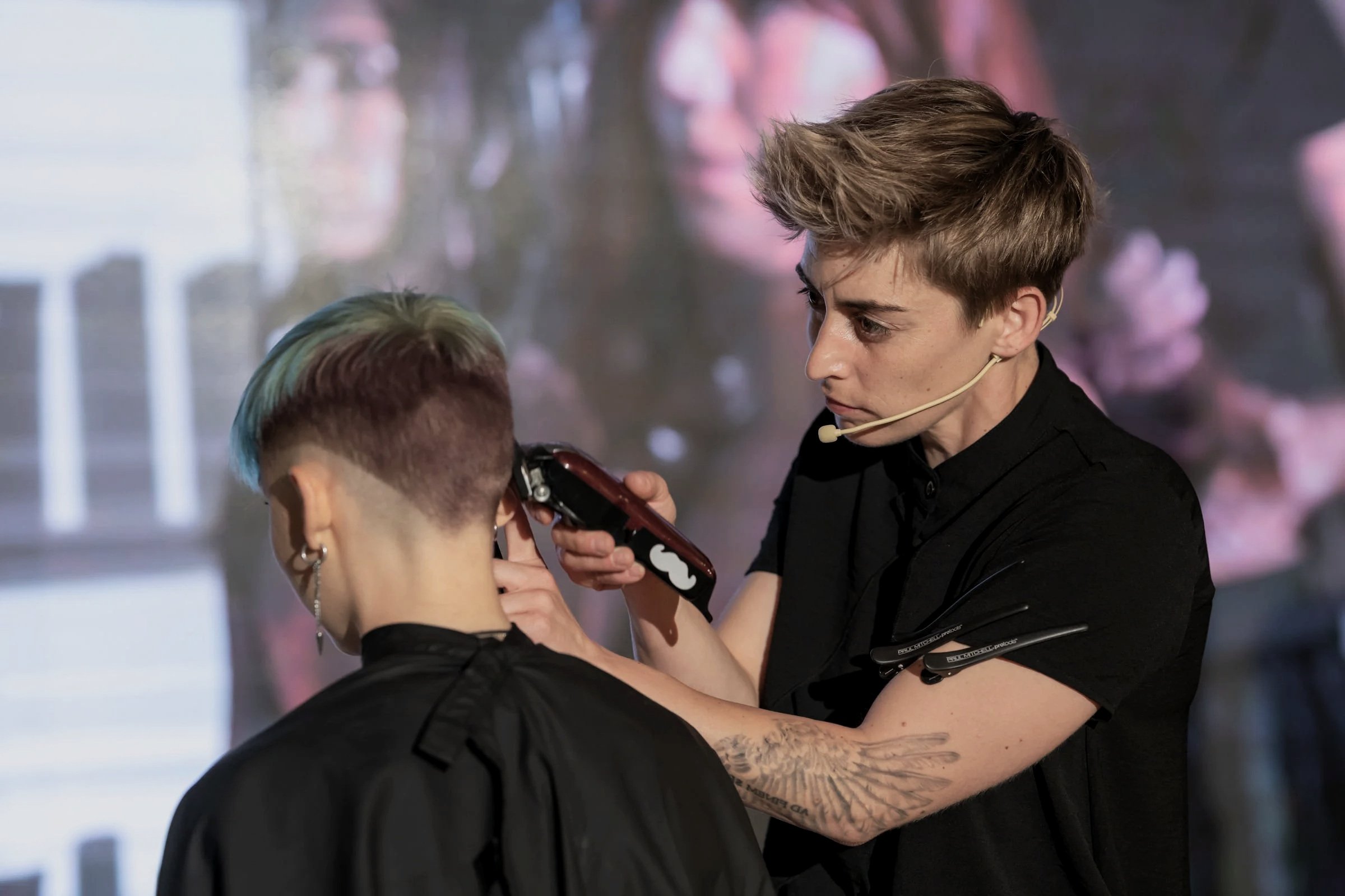 Hairdresser performing haircut on stage