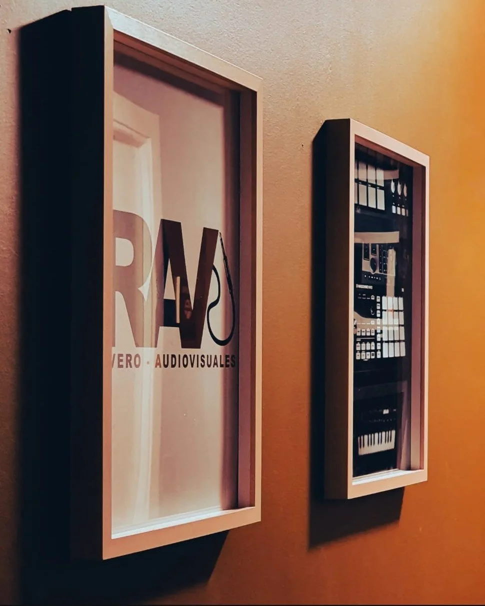 Dos cuadros decorativos en la pared, uno con la palabra 'RAV' y el otro con instrumentos y equipo de música.