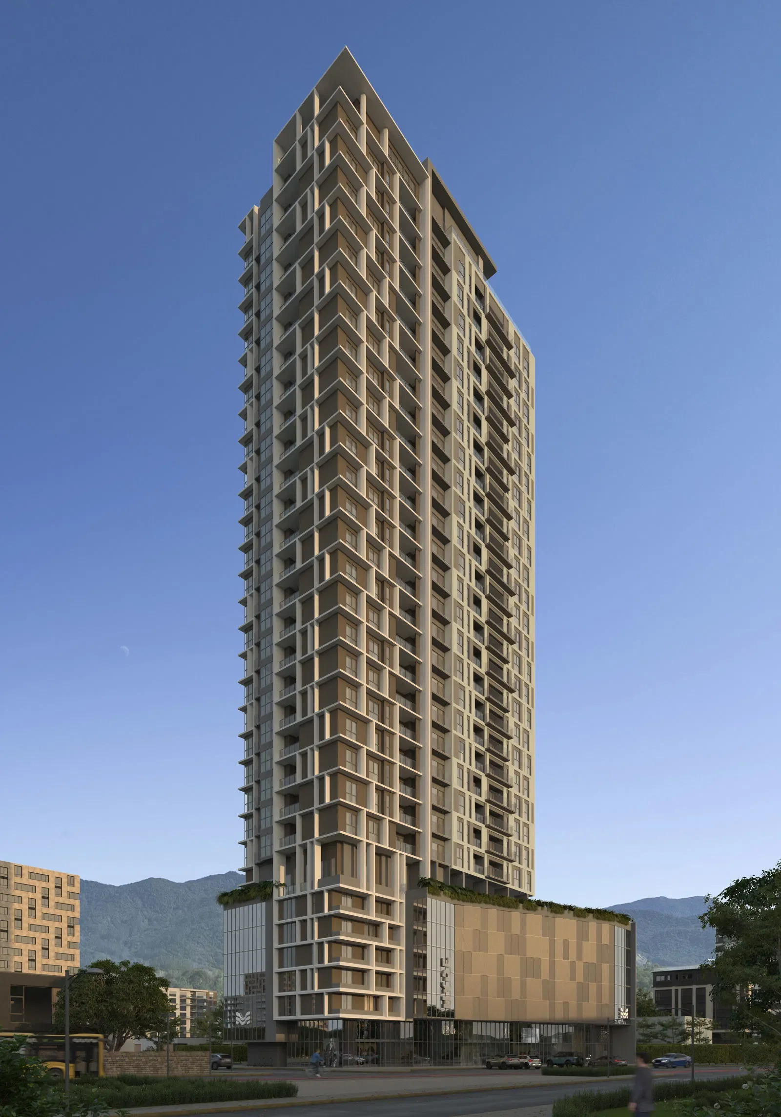 Prédio alto moderno com muitos andares, janelas e varandas, situado na cidade com montanhas ao fundo.