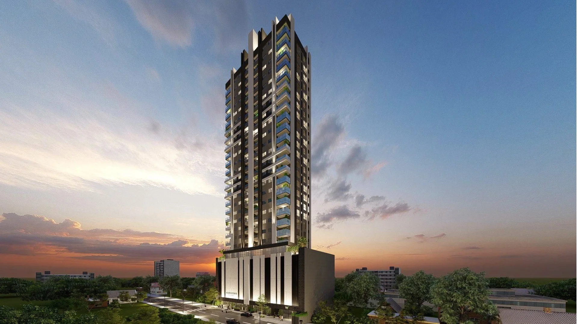 Prédio de alto padrão com muita iluminação, área ao redor com árvores e ruas, ao entardecer, céu com nuvens e Guaíra Shopping ao fundo.