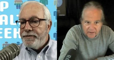 Two men with gray hair and glasses speaking into microphones in a video call or podcast setting.