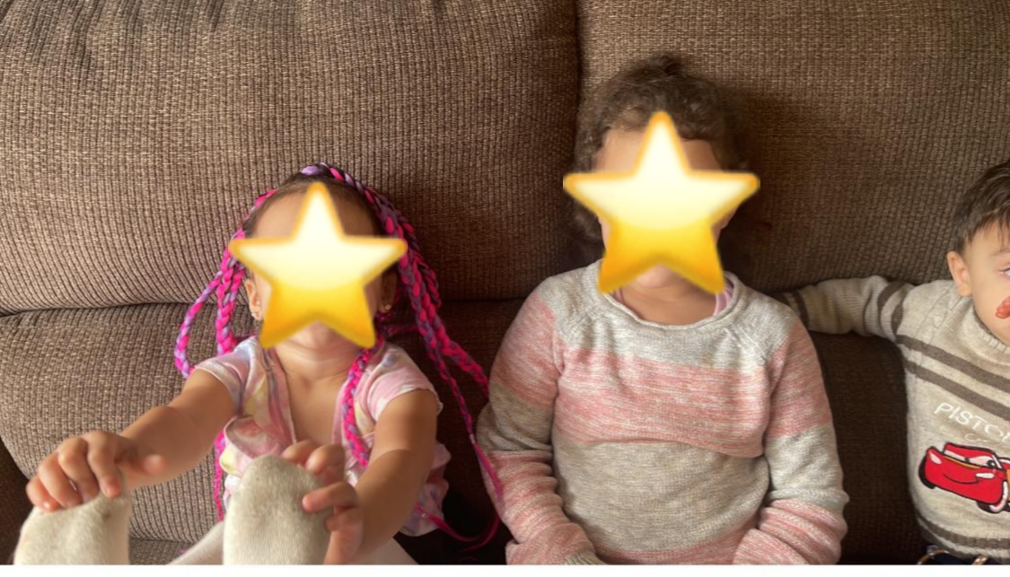 Three children sitting on a brown couch with star-shaped overlays covering their faces.
