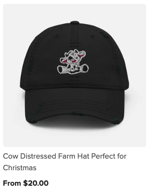 Black baseball cap with an embroidered distressed cow cartoon holding a red Christmas ornament.
