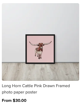 Framed pink poster of a longhorn cattle with large horns, leaning against a white wall on a light hardwood floor.