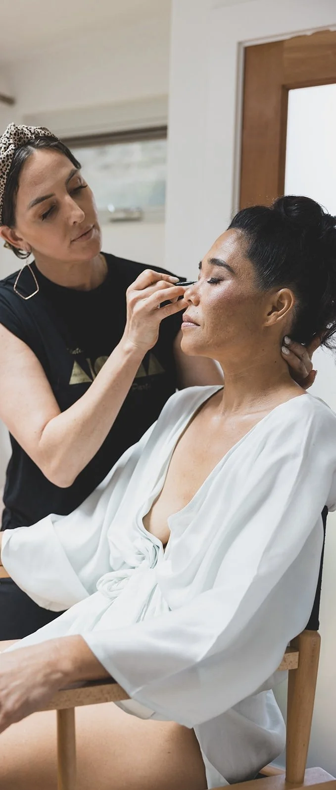 Bridal hair and makeup artist Lynzy applying makeup to a destination bride in Maui, Hawaii