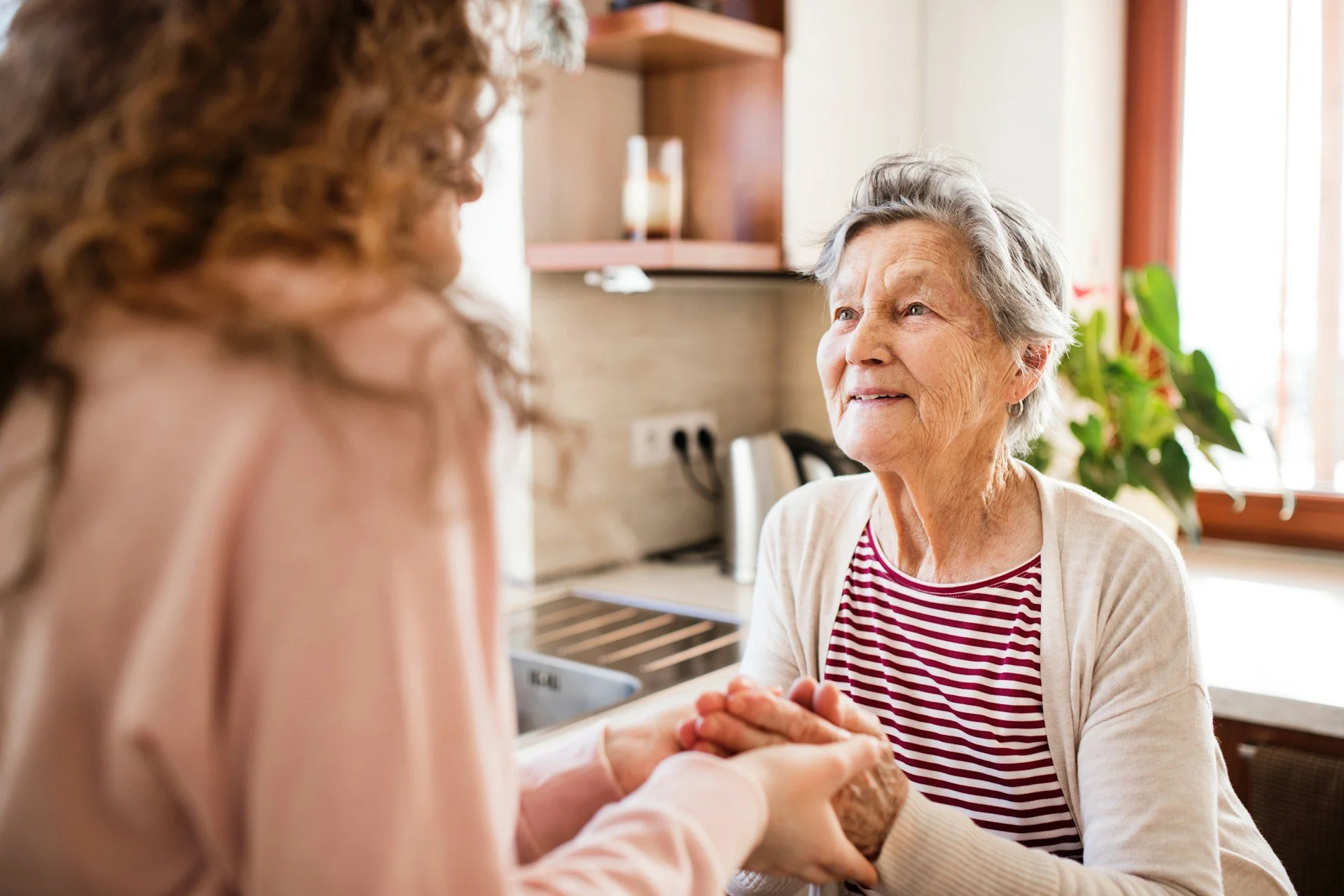 older woman talking with well care at home in-home aide