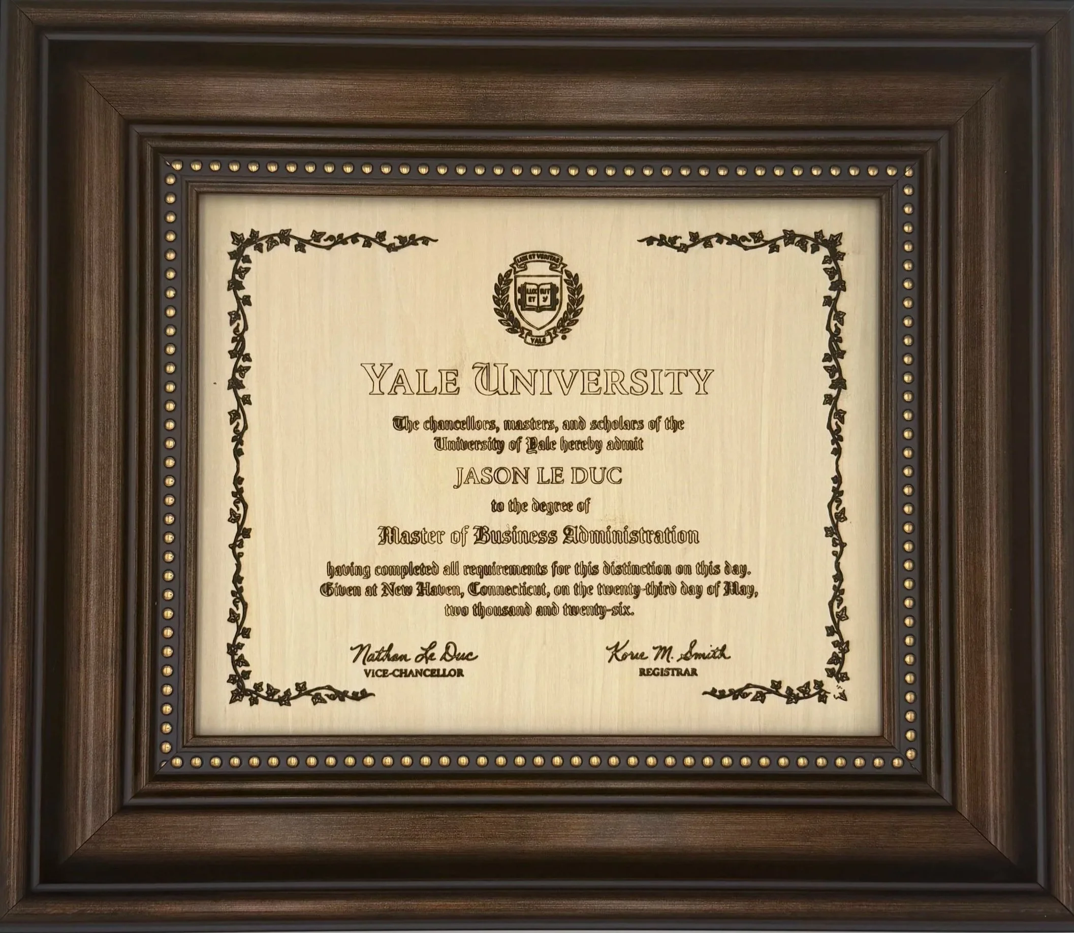 A framed Yale University diploma with decorative borders and gold accents on the frame.