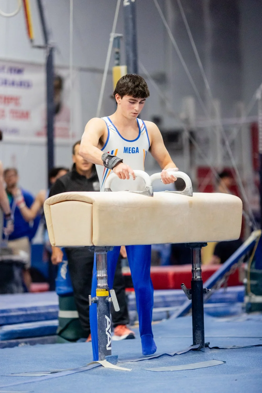 Male gymnast preparing on the pommel horse during a gymnastics competition.